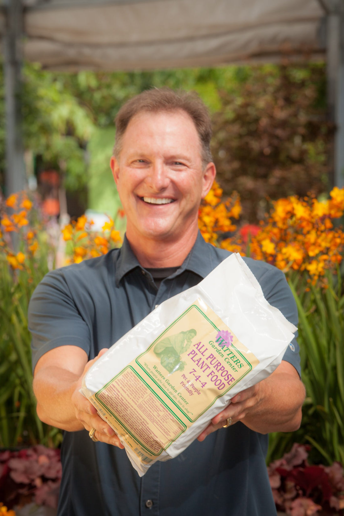 KEn Lain holding All Purpose Plant Food